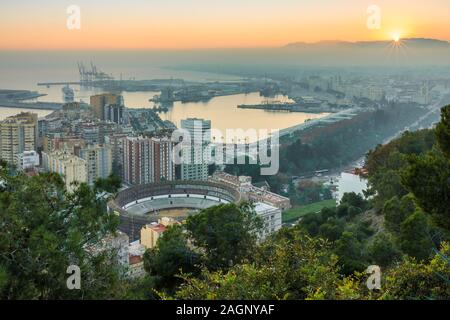 Panoramablick auf Málaga bei Sonnenuntergang an der spanischen Costa del Sol mit Panoramablick auf die Stadt, den Hafen, die Häuser, die Bäume und die Stierkampfarena Stockfoto