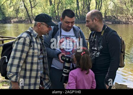 Ivanovo, Serbien, April 09, 2017. Eine Gruppe von Fotografen und ein Mädchen am Ufer des Flusses teilen ihre Erfahrungen. Stockfoto