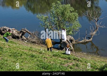 Ivanovo, Serbien, April 09, 2017. Fotografen in Aktion und ein Model posiert als Nymphe auf einem Baum am See. Stockfoto