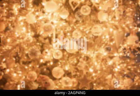 Defokussierten Christbaumschmuck, golden funkelnden bokeh Hintergrund, glänzenden Holz Spielzeug Stockfoto