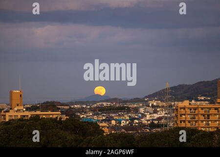 Vollmond über entfernten Berg in der kleinen japanischen Stadt in der Dämmerung Stockfoto