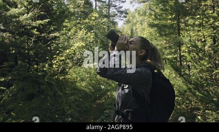 Traveler fotografieren malerischen Blick in den Wald. Eine kaukasische Frau schießen nettes Magic suchen. Mädchen nehmen Foto Video auf dslr spiegellosen Kamera. Stockfoto