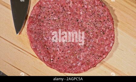 Kochen macht Fleisch Medaillons für Burger. Koch in schwarz Handschuhe macht Schnitzel essen. Die koteletts sind in Stahl Ring in eine noch Medaillon eingeebnet. Stockfoto