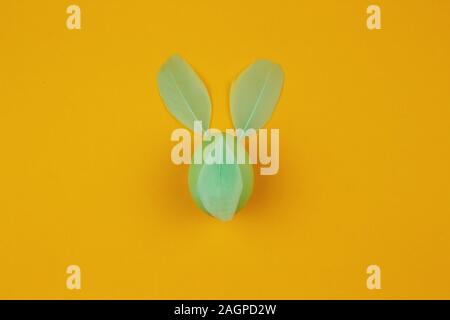 Nette kreative Foto mit Osterei mit Feder wie der Osterhase. Minimale Ostern Konzept. Stockfoto
