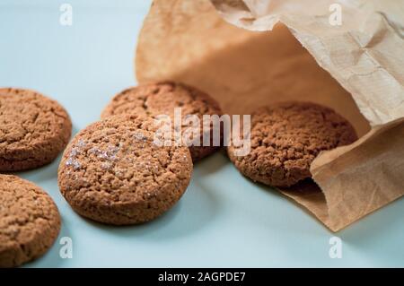 Cookies skattered auf weiße Oberfläche aus Papier kaufen Tasche Stockfoto