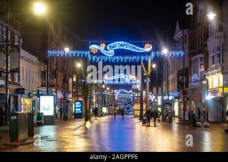 Weihnachtsbeleuchtung aufhängen in der Broad Street in Reading, Berkshire in der Nacht. Stockfoto