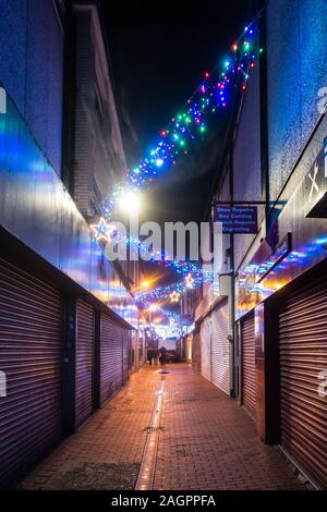 Weihnachtsbeleuchtung Zickzack entlang der Union Street in Reading, Großbritannien hier bei Nacht gesehen. Die Geschäfte sind mit Fensterläden geschlossen. Stockfoto