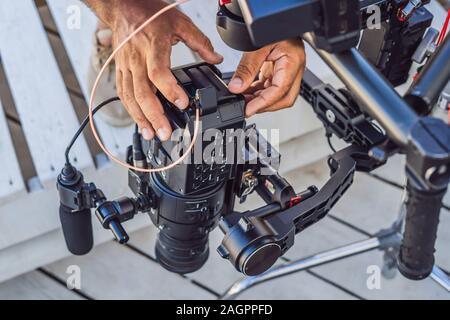 Steadicam operator und sein Assistent Vorbereiten der Kamera und 3-Achs Stabilisator - Gimbal für eine kommerzielle Schießen Stockfoto