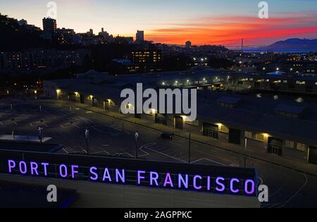 Hafen von San Francisco mit der Golden Gate Bridge in der Entfernung in der Abenddämmerung. Stockfoto