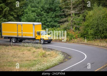 Big Rig gelb Tag cab Semi Truck für die lokalen Lieferungen Transport von kommerziellen Ladung in Box Anhänger mit Aufzug auf der Rückseite, auf die City Road wit Stockfoto