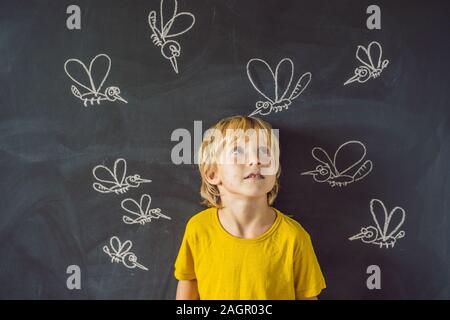 Der Junge wird durch Moskitos auf einem dunklen Hintergrund gebissen. Auf der Tafel mit Kreide gemalt Moskitos Stockfoto