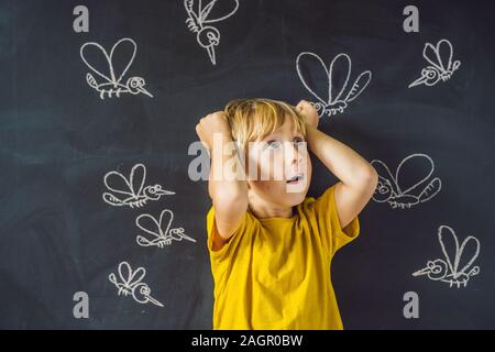 Der Junge wird durch Moskitos auf einem dunklen Hintergrund gebissen. Auf der Tafel mit Kreide gemalt Moskitos Stockfoto