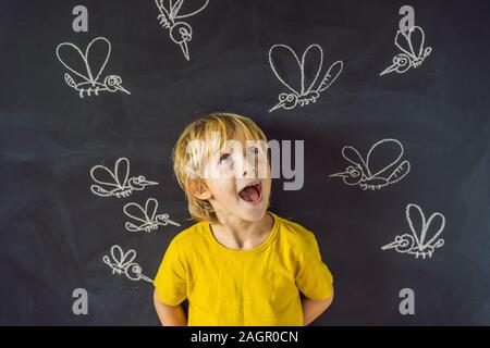 Der Junge wird durch Moskitos auf einem dunklen Hintergrund gebissen. Auf der Tafel mit Kreide gemalt Moskitos Stockfoto