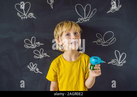 Der Junge wird durch Moskitos eine fumigator auf einem dunklen Hintergrund gebissen. Auf der Tafel mit Kreide gemalt Moskitos Stockfoto