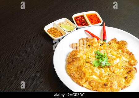 Im thailändischen Stil ei Omelette isoliert, und in einem weißen Teller mit Chili padi. Stockfoto