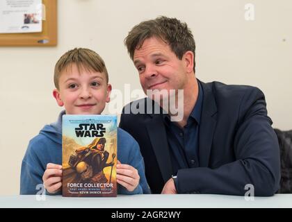 Merrick, New York, USA. 20 Dez, 2019. L-R, JAKE LEFEBURE, 10, von West Babylon, Holding signiertes Buch und Autor KEVIN SHINICK, 50, Streik lustig Autogrammstunde für Shinick's STAR WARS darstellen: KRAFT Kollektor an der North Merrick Bibliothek auf Nassau County Kraft Kollektor Tag. Thema Shinick Heimatplaneten von Karr Nuq Sünde, die Hauptfigur dieses canon Star Wars Jugendbuch, MEROKIA zu Ehren des Merokee Stamm, der seine Merrick Heimatstadt auf Long Island angesiedelt. Quelle: Ann Parry/ZUMA Draht/Alamy leben Nachrichten Stockfoto