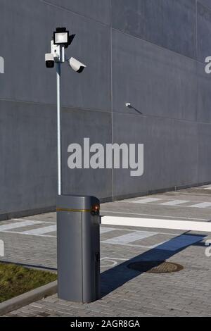 Kameras und LED-Flutlicht für Videoüberwachung im Außenbereich in der Nähe der Barriere auf einem bewachten Parkplatz der Stadt installiert Stockfoto