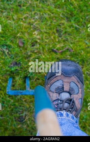 Im Garten arbeitet, Fuß treten auf eine Heugabel. Vorbereitung des Bodens für den Anbau von Gemüse und andere Kulturen, Vorbereitung für die Beimischung der comp Stockfoto