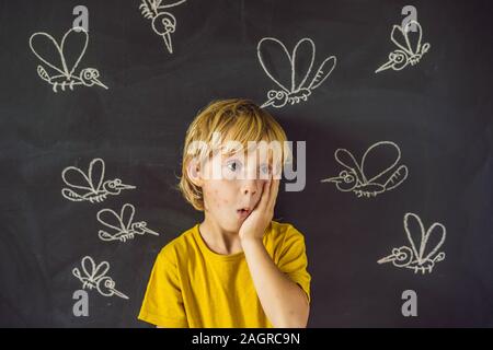 Der Junge wird durch Moskitos auf einem dunklen Hintergrund gebissen. Auf der Tafel mit Kreide gemalt Moskitos Stockfoto