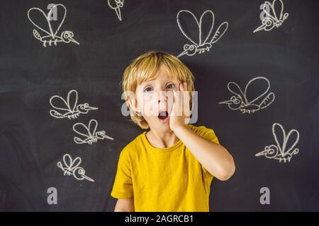 Der Junge wird durch Moskitos auf einem dunklen Hintergrund gebissen. Auf der Tafel mit Kreide gemalt Moskitos Stockfoto