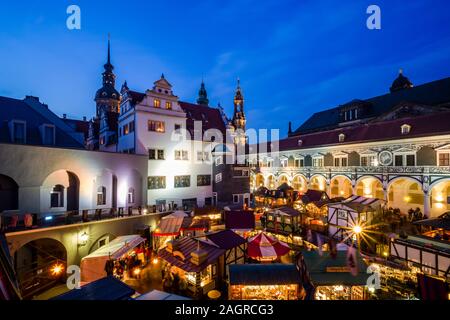 Bunt beleuchtete Mittelalterlicher Weihnachtsmarkt im Innenhof der Hausmannsturm Stallhof, Turm und die Kathedrale hinter Stockfoto