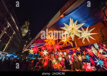 Bunte Herrnhuter Sterne sind für Verkauf an den bunt beleuchteten Weihnachtsmarkt vor der Kirche Unserer Lieben Frau Stockfoto