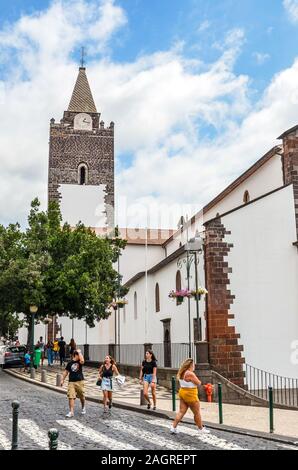 Funchal, Madeira, Portugal - September 10, 2019: Straße in der Altstadt der Hauptstadt Madeiras mit dominierenden Kathedrale Unserer Lieben Frau von der Himmelfahrt. Menschen zu Fuß auf den Straßen. Vertikale Foto. Stockfoto