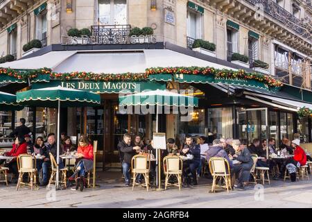 Paris Les Deux Magots - Gönner genießen Sie die Wintersonne im Les Deux Magots Cafe in der Saint-Germain-des-Prés von Paris, Frankreich, Europa. Stockfoto