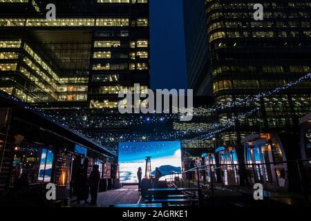 Die Menschen genießen einen Drink vor dem Winter Szene an Weihnachten in Kanada Platz am Canary Wharf, Docklands Stockfoto