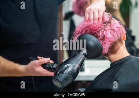 Stylist trocknet Frau Haar im Beauty Salon. Stockfoto