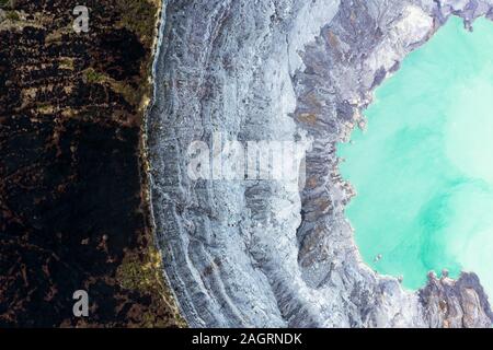 Ansicht von oben, beeindruckende Luftaufnahme des Ijen Vulkan mit dem türkisfarbenen sauren Crater Lake. Stockfoto