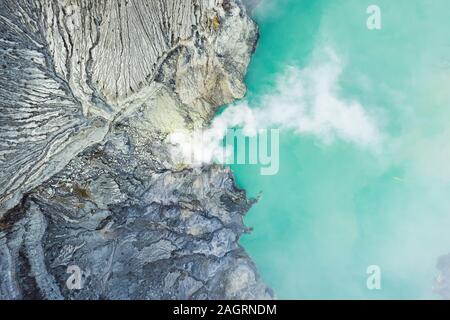 Ansicht von oben, beeindruckende Luftaufnahme des Ijen Vulkan mit dem türkisfarbenen sauren Crater Lake. Stockfoto