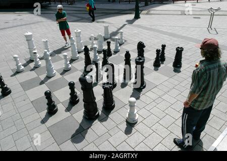 Zwei Leute an einem riesigen im Freien Schach in Christchurch, Neuseeland, Reise Set spielen, Stockfoto