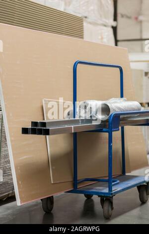 Trolley in einem Hardware-store mit Baumaterial geladen. Reparatur und Konstruktion Konzept. vertikale Foto. Stockfoto