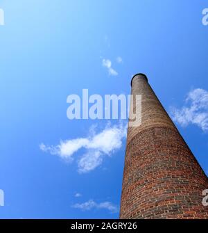 Hoch aus rotem Backstein Schornstein auf einem roten Ziegeldach