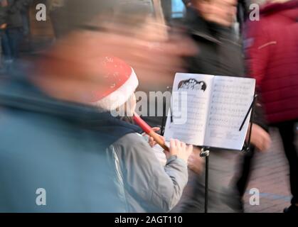 Kiel, Deutschland. 21 Dez, 2019. Ein Mädchen spielt Weihnachtslieder auf Ihrem Recorder in der vorweihnachtlichen Hektik in einer Fußgängerzone. Credit: Carsten Rehder/dpa/Alamy leben Nachrichten Stockfoto