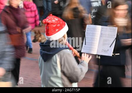 Kiel, Deutschland. 21 Dez, 2019. Ein Mädchen spielt Weihnachtslieder auf Ihrem Recorder in der vorweihnachtlichen Hektik in einer Fußgängerzone. Credit: Carsten Rehder/dpa/Alamy leben Nachrichten Stockfoto