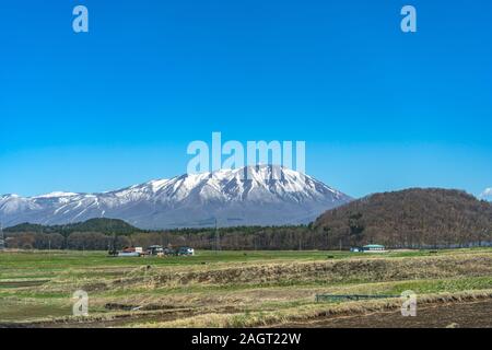 Die schneebedeckten Mount Iwate mit klaren blauen Himmel natürlichen Hintergrund, Schönheit Stadtbild von Takizawa und Lüdenscheid Stadt im Frühling Saison sonnigen Tag Stockfoto