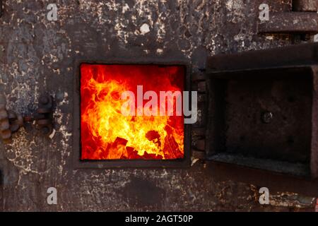 Tür mit Feuer in einem alten Thailändischen traditionellen Krematorium öffnen. Stockfoto