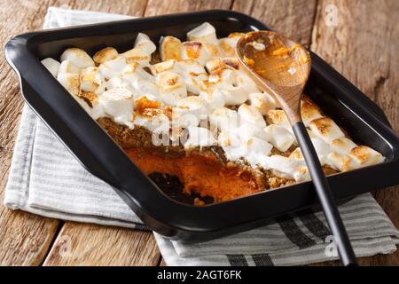 Süsse Kartoffel Auflauf mit Pekannüssen gekrönt mit Marshmallows close-up in einer Auflaufform auf den Tisch. Horizontale Stockfoto