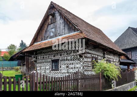 Alte Holzhäuser in der Slowakei Dorf Cicmany im Herbst. Einzigartige Dekoration der Holzhäuser von Mustern in traditionelle Stickereien in Dorf o verwendet wird Stockfoto