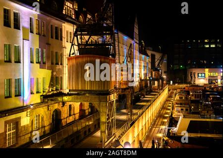 Berlin, Deutschland - 20 Dezember, 2019: nachts beleuchtete Szene an einem historischen Hafen in Berlin, Deutschland, mit nummerierten alte Cargo Cranes. Stockfoto