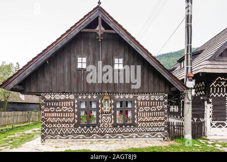 Alte Holzhäuser in der Slowakei Dorf Cicmany im Herbst. Einzigartige Dekoration der Holzhäuser von Mustern in traditionelle Stickereien in Dorf o verwendet wird Stockfoto