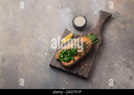 Gebratenes Lachssteak mit Spargel auf Holzbrett, kopieren Raum Stockfoto