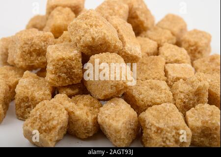 Ein Haufen brauner Zucker Stücke auf einem weißen Hintergrund close-up Stockfoto