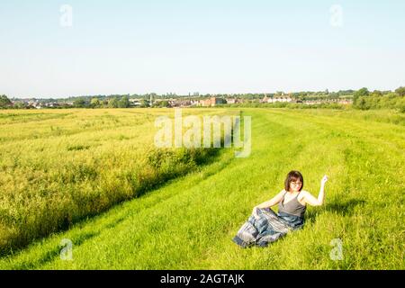 Juni 26, 2019 - Gainsborough, Lincolnshire, Großbritannien. Ein erwachsenes Weibchen stand auf einem Gras riverbank Holding ihr Arm in der Luft. Das Wetter ist Sunn Stockfoto