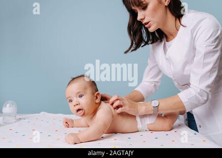 Frau Kinderarzt tun Massage baby boy Stockfoto