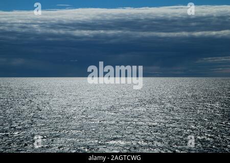 Das Bild von einer Fähre zwischen Schweden und Finnland. Der Kontrast zwischen der dunklen Wolkenhimmel und hellen Wasser mit Sonne Reflexion. Stockfoto