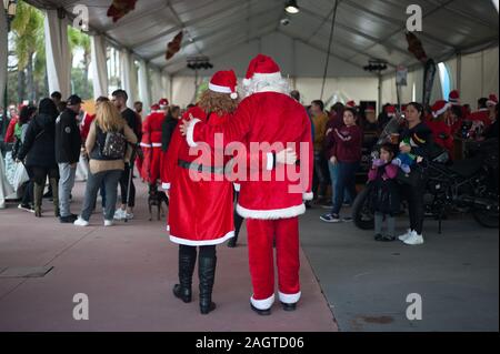 Malaga, Spanien. 21 Dez, 2019. Ein paar in Santa Claus Kostümen posieren für ein Foto während der V Toy Run Torremolinos. jedes Jahr Hunderte von Motorradfahrern in der Innenstadt von Torremolinos in einem Charity Rennen in Santa Claus Kostümen und Sammeln von Spielzeug für Kinder zu beteiligen. Credit: SOPA Images Limited/Alamy leben Nachrichten Stockfoto