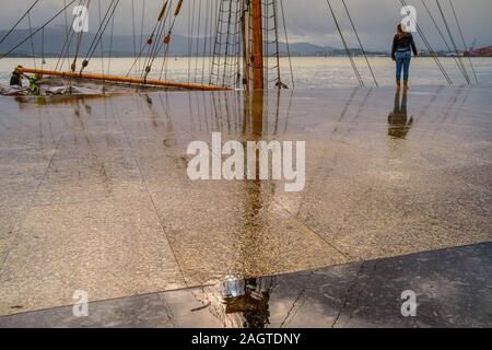 Leute, die an einem regnerischen Tag entlang der Strandpromenade Muelle Calderon, Paseo de Pereda. Kantabrischen Meer Santander. Kantabrien, Spanien. Europa Stockfoto